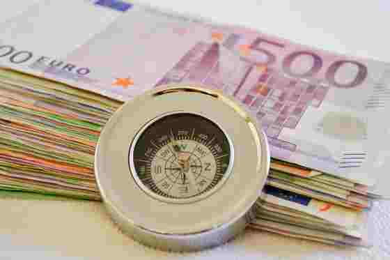 Geldscheine mit eine Kompass davor