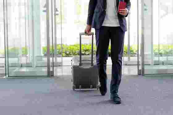 Mann mit Koffer am Flughafen